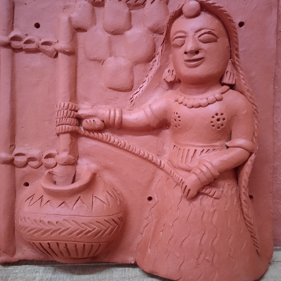 Terracotta woman churning milk