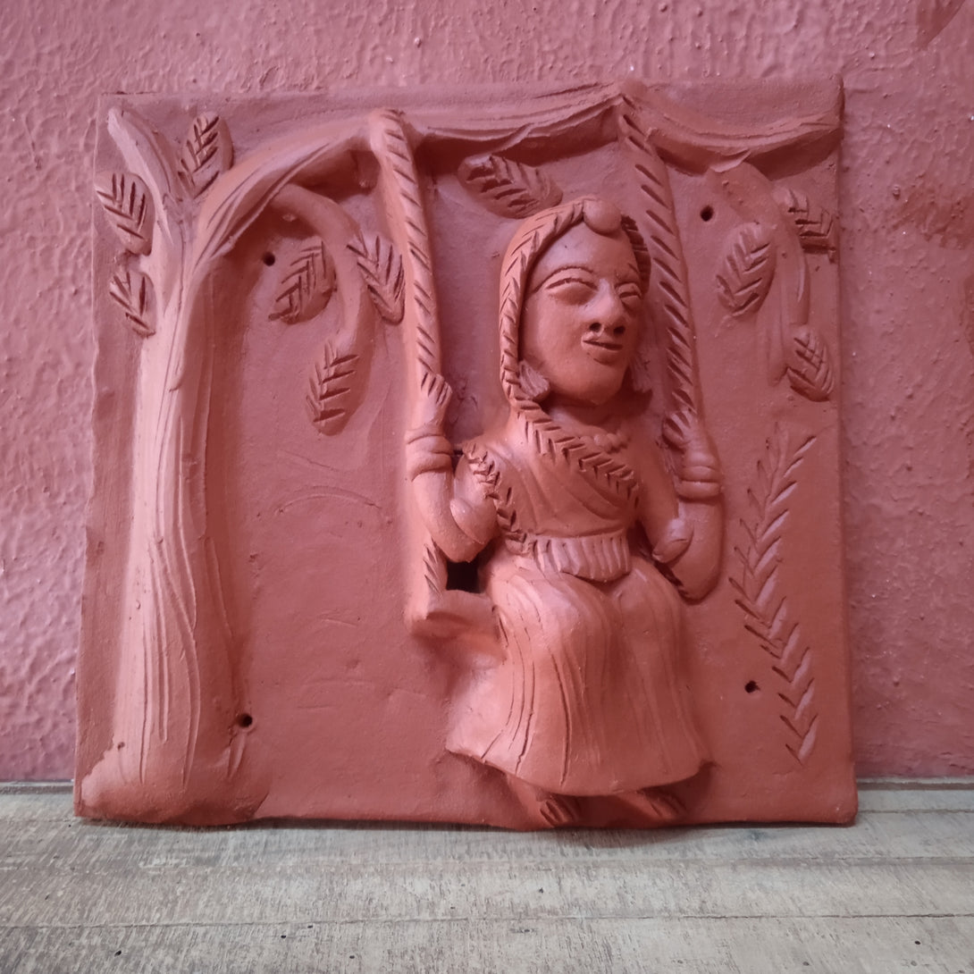 Terracotta woman on swing